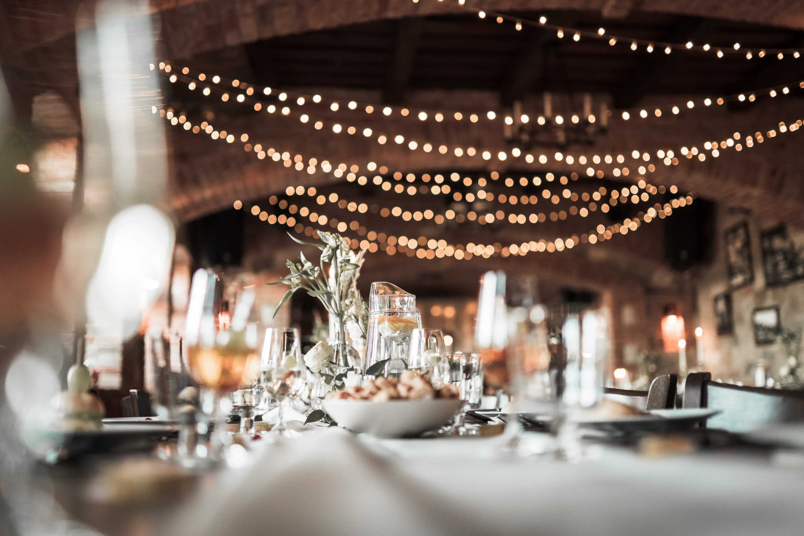 beautiful wedding room with wedding table with food, flowers anddrinks, decorations,lights